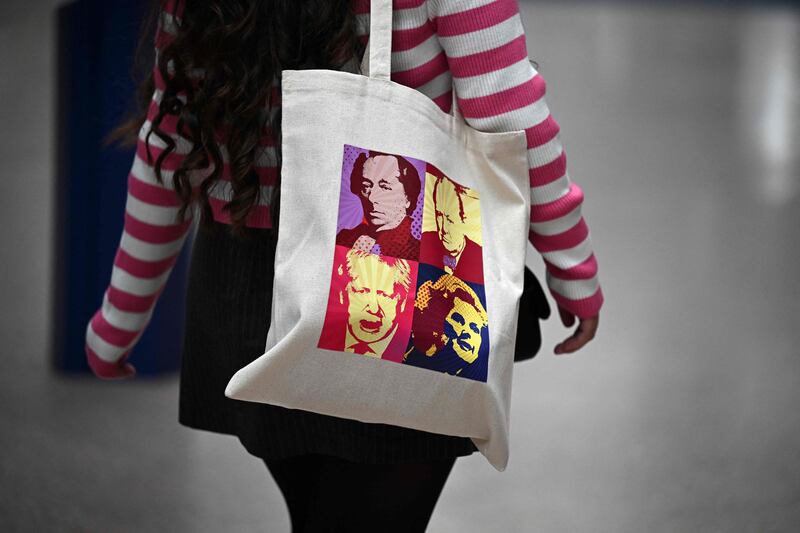 A delegate is pictured with a bag displaying pictures of former Conservative prime ministers Benjamin Disraeli, Winston Churchill, Boris Johnson and Margaret Thatcher. AFP