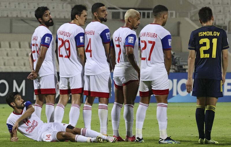 Sharjah's midfielder Khaled Ba Wazir lays down behind the wall. AFP