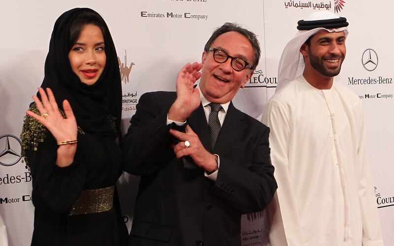 ADFF Executive Director Peter Scarlet (C) and the president of Our World Jury Amal al-Ghaferi (L) wave as they stand next to Project Director Issa Saif Rashed al-Mazrouei on the red carpet at the opening ceremony of the fifth Abu Dhabi Film Festival (ADFF) in the United Arab Emirates' capital on October 13, 2011.  AFP PHOTO/JOSEPH CAPELLAN
 *** Local Caption ***  045755-01-08.jpg