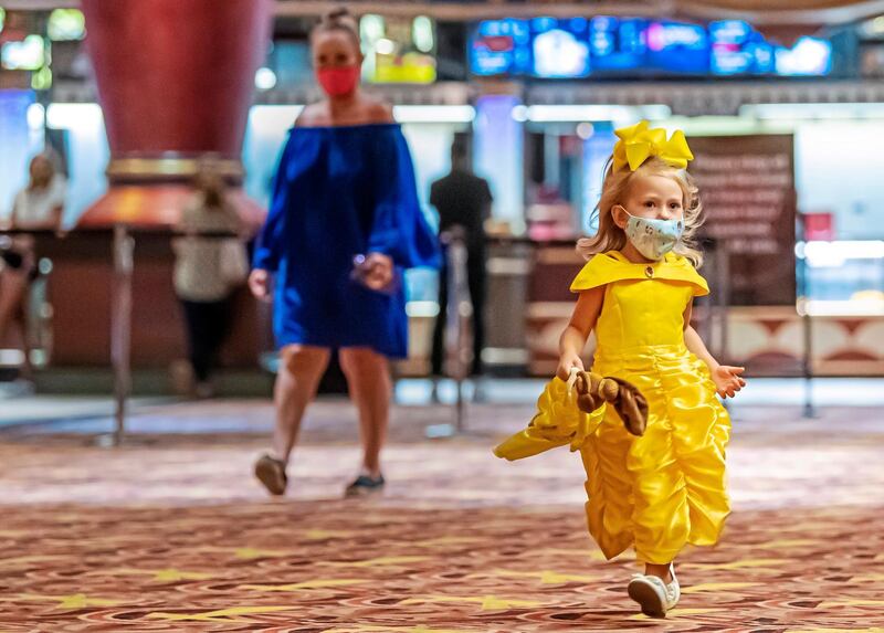 Dressed as Disney's Belle, Lilly Stevenson, 3, of McMurray, Pennsylvania, holds her Belle doll as she makes her way to see "Beauty and the Beast," during AMC Waterfront movie theater's reopening in West Homestead, Pennsylvania. Pittsburgh Post-Gazette via AP