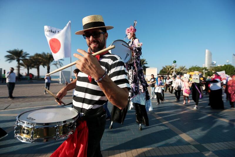 Musicians, dancers and stilt walkers entertain the crowds at the Yasalam F1 Fan Zone opening parade along the Corniche in Abu Dhabi. Christopher Pike / The National