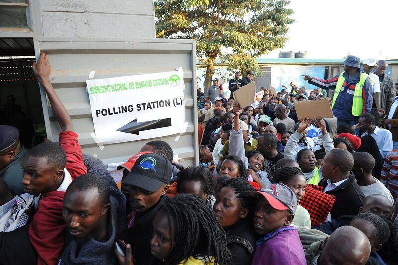 Kenyans in the Dandora neighborhood of Nairobi wait to vote at James Gichuru Primary School on March 4, 2013. Long lines of Kenyans queued from far before dawn to vote Monday in critical elections, the first since violent polls five years ago, with five policemen killed in an ambush in Mombasa hours before polling started. AFP PHOTO/Jennifer Huxta

