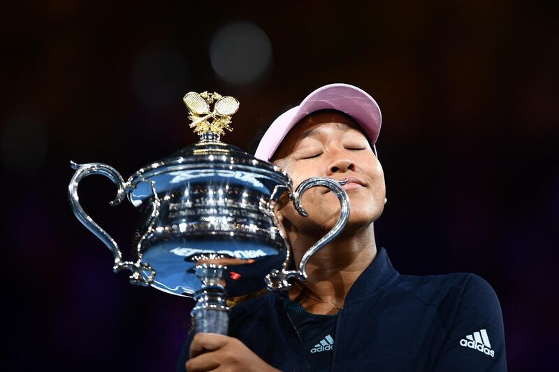 Japan's Naomi Osaka celebrates with the championship trophy during the presentation ceremony after her victory against Czech Republic's Petra Kvitova in the women's singles final on day 13 of the Australian Open tennis tournament in Melbourne on January 26, 2019. (Photo by Jewel SAMAD / AFP) / -- IMAGE RESTRICTED TO EDITORIAL USE - STRICTLY NO COMMERCIAL USE --