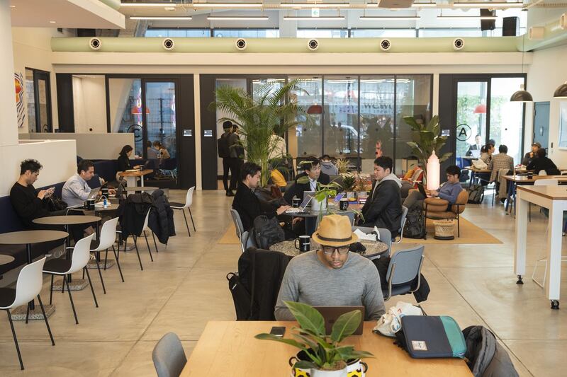 Members sit and use laptop computers at the WeWork Cos. Iceberg co-working space in Tokyo, Japan, on Thursday, Dec. 20, 2018. The office-sharing giant, valued at as much as $42 billion, is getting a greater portion of its business from the large companies that property owners usually court. It's also building an investment division to buy its own sites, according to people with knowledge of the matter. Photographer: Keith Bedford/Bloomberg