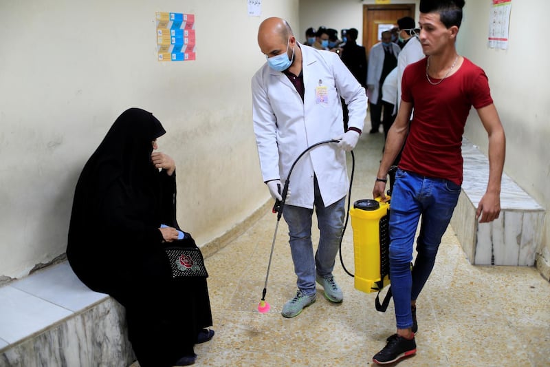 A member of the medical team sprays disinfectant in a dental clinic in Sadr city district of Baghdad, Iraq, March 9, 2020. Reuters