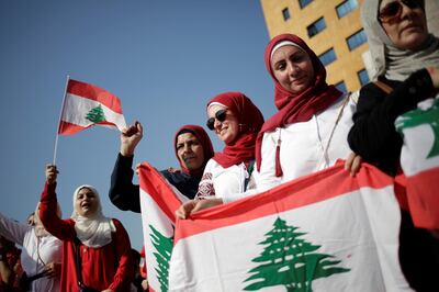 Women carry national flags during ongoing anti-government protests near the Ministry of Education and Higher Education in Beirut, Lebanon November 7, 2019. REUTERS/Andres Martinez Casares