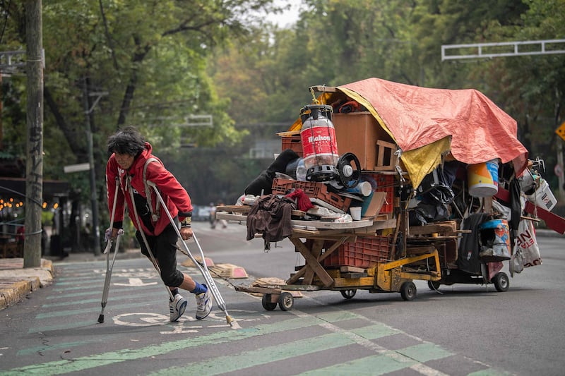 A homeless man pulls a cart carrying his belongings along the road in Mexico City. AFP