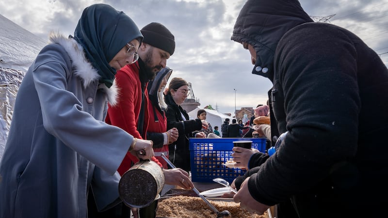 Aid workers serve food to the inhabitants of the camp. The quake killed at least 300 people in Osmaniyeh