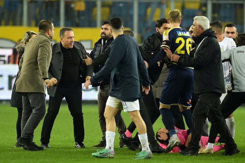 Referee Halil Umut Meler is seen lying on the ground, right, after being punched by MKE Ankaragucu president Faruk Koca, second from left, at the end of the Turkish Super Lig soccer match between MKE Ankaragucu and Caykur Rizespor in Ankara, Monday, Dec.  11, 2023.  The Turkish Football Federation has suspended all league games in the country after a club president punched the referee in the face at the end of a top-flight match.  Koca was arrested Tuesday, Dec.  12, 2023, along with two other people on charges of injuring a public official following questioning by prosecutors.  (Abdurrahman Antakyali / Depo Photos via AP)