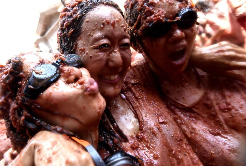 Revellers covered in smashed tomatoes take part in the Tomatina festival in Bunol. AFP