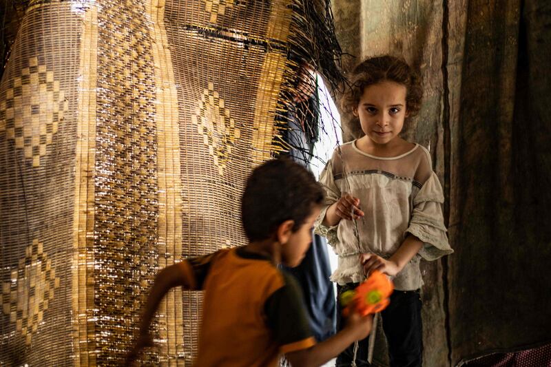 Syrian children, displaced with their family from Deir Ezzor, play in a damaged building where they now live in Syria's northern city of Raqqa.
