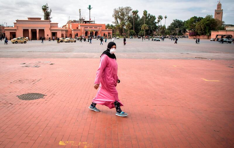 A Morrocan woman wearing a protective mask walks through the nearly deserted Jamaa el-Fna square in the heart of Marrakesh. AFP