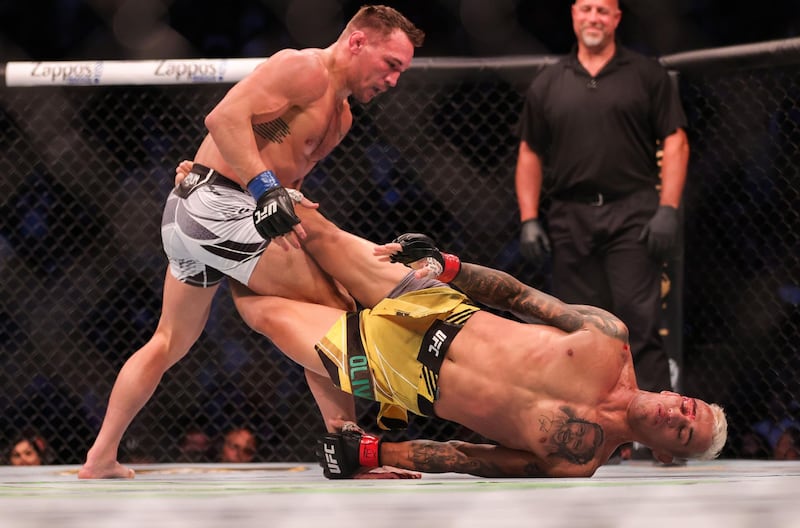 Charles Oliveira wrestles with Michael Chandler. AFP