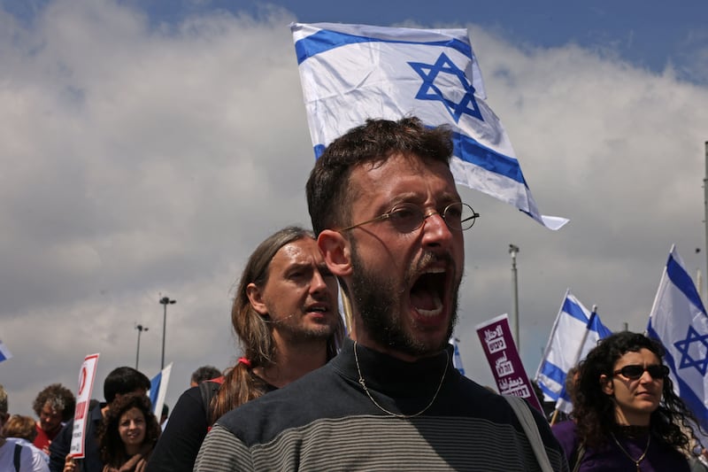 Protesters hold up Israeli flags and placards at the Knesset. AFP