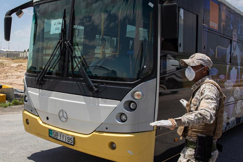 Members of Jordan's security forces check a bus that will transport returning Jordanian students from abroad.  EPA