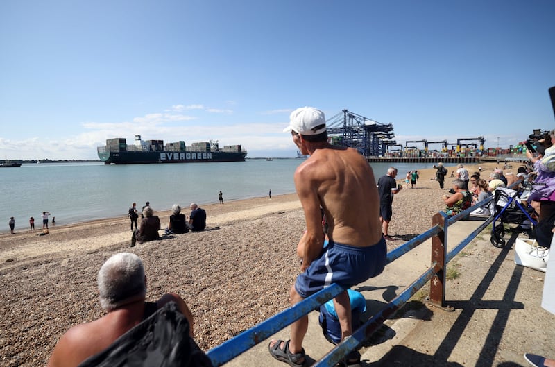 Spectators watch as the container ship Ever Given arrives at the Port of Felixstowe Ltd.  in Felixstowe, U. K. , on Tuesday, Aug.  3, 2021.  The giant container ship that had blocked Egypt’s Suez Canal for nearly a week earlier this year was released on July 7 following an agreement between authorities and the vessel’s owners. Photographer: Chris Ratcliffe / Bloomberg