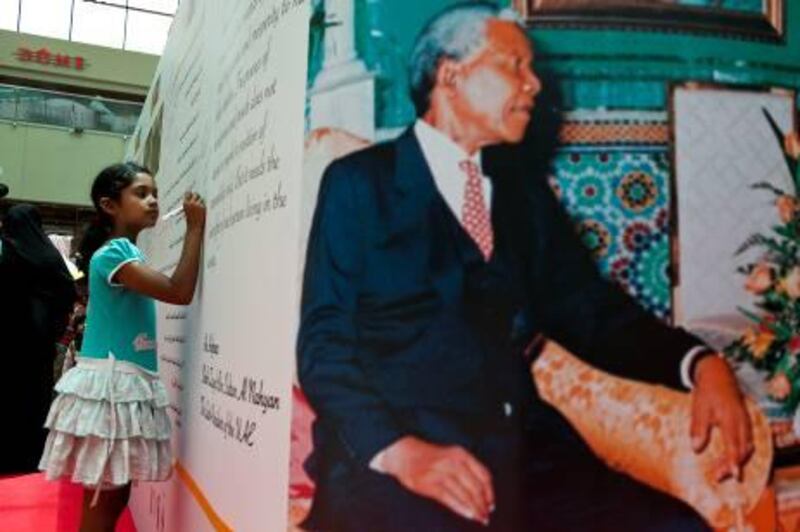 Monal Rasquinha, a student at Emirates Future International Academy in Abu Dhabi, signs the mural at Khalidiya Mall in honour of Nelson Mandela’s birthday.
