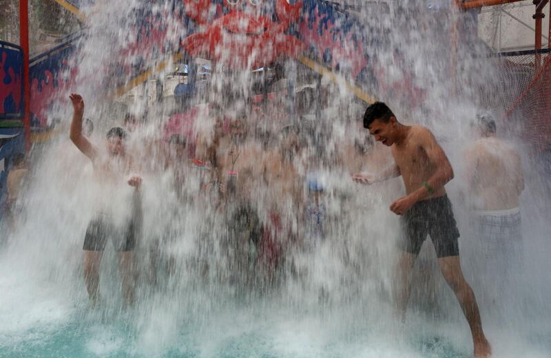 Iraqis cool themselves at an indoor water park during a heatwave in the capital Baghdad.  AFP
