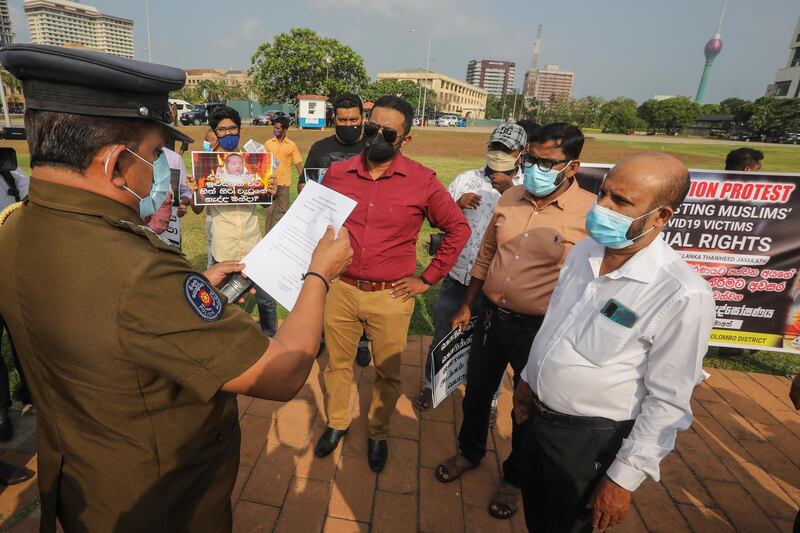 A Sri Lanka police officer explains a court order against protests to members of the Sri Lanka Thawheed Jamaath, a Muslim religious organization near the Presidential Secretariat in Colombo, Sri Lanka. Sri Lanka Thawheed Jamaath organized what it called an 'attention protest' against the current cremation of Muslim Covid-19 victims, claiming that Islam does not allow it. However, the government and health authorities continue to cremate such bodies as they are still not sure of the consequences of burying infected bodies claiming the high humidity of the island's soil.  EPA