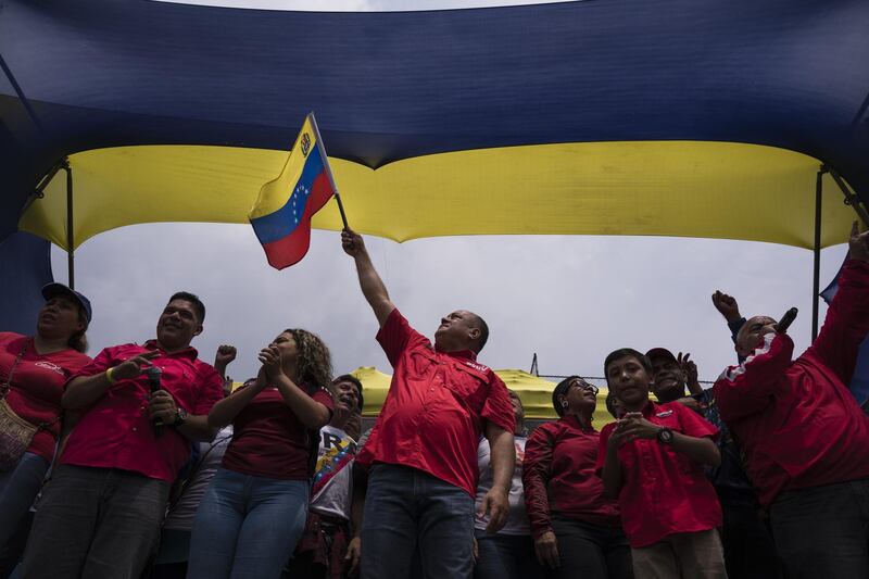 Diosdado Cabello, president of the National Constituent Assembly, centre, waves a Venezuelan flag during an anti-imperialist rally in Caracas, Venezuela. Bloomberg