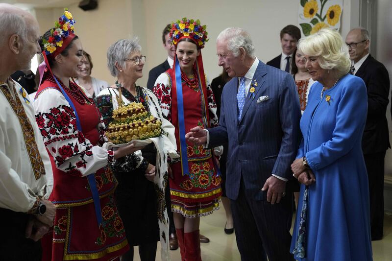 Britain's Prince Charles and Camilla, Duchess of Cornwall, are presented with bread and salt during a visit to a Ukrainian church in Ottawa on their Canadian Royal Tour, May 18, 2022. AFP