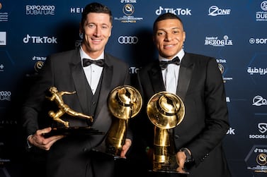 This handout picture made available by the Dubai Globe Soccer Awards on December 27, 2021 shows (L to R) Polish footballer Robert Lewandowski posing for a photo with his awards "Maradona Award for Best Goal Scorer of the Yea" and the "TikTok Fans Player of the Year"; alongside French footballer Kylian Mbappe, winner of the "Best Men's Player of the Year" award during the 2021 Globe Soccer Awards at the Burj Khalifa in the gulf emirate.  (Photo by Elmer MAGALLANES  /  Dubai Globe Soccer Awards  /  AFP)  /  === RESTRICTED TO EDITORIAL USE - MANDATORY CREDIT "AFP PHOTO  /  HO  /  Dubai Globe Soccer Awards" - NO MARKETING NO ADVERTISING CAMPAIGNS - DISTRIBUTED AS A SERVICE TO CLIENTS ===