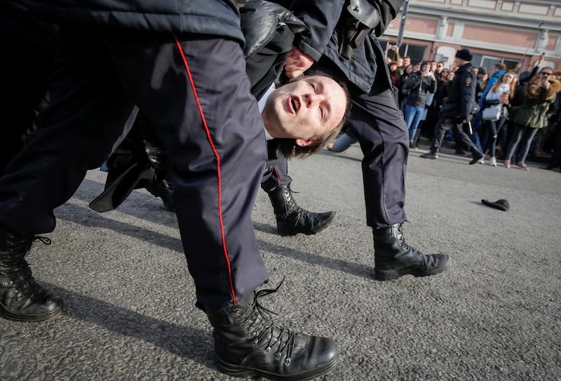 Russian police officers detain an opposition supporter during a rally in Moscow. Maxim Shemetov / Reuters
