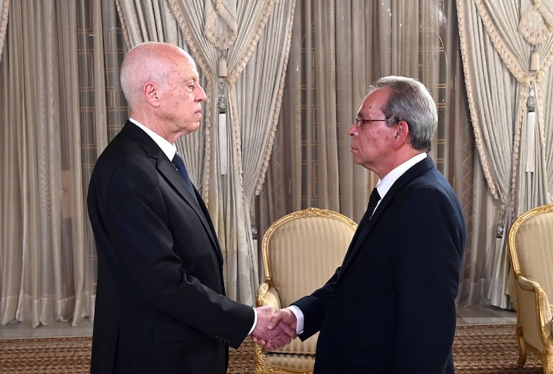 Tunisian President Kais Saied, left, shakes the hand of new Prime Minister Ahmed Hachani at the presidential palace on Tuesday. EPA
