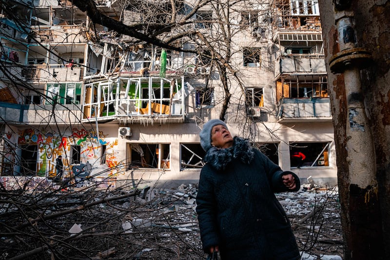 A woman looks a building damaged by Russian shelling in Kherson. AFP