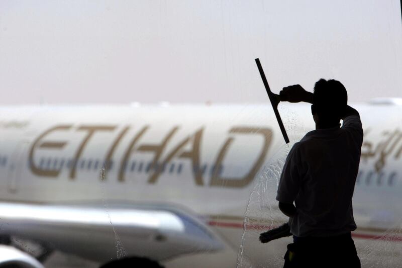 A worker cleans a window at Terminal 3 at Abu Dhabi International Airport. Jaime Puebla / The National