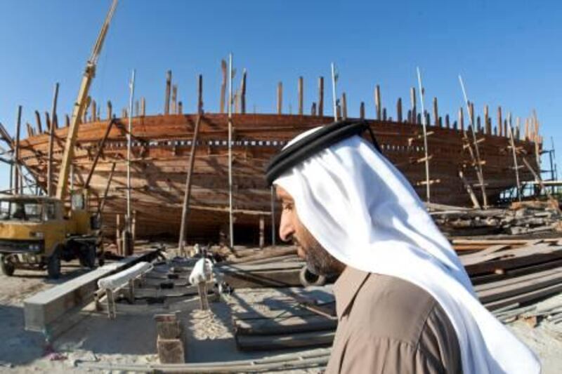 Dubai, December 30, 2010 - Dhow builder Huraiz Ahmad binToug Al Merri walks past the dhow he and his brother Salah are having points built at the Jadaf Drydocks in Dubai, December 30, 2010. (Jeff Topping/The National)