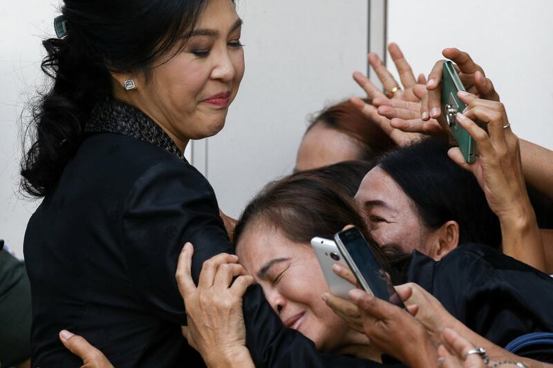 Ousted Thai prime minister Yingluck Shinawatra greets supporters as she leaves the Supreme Court in Bangkok, Thailand. Athit Perawongmetha.