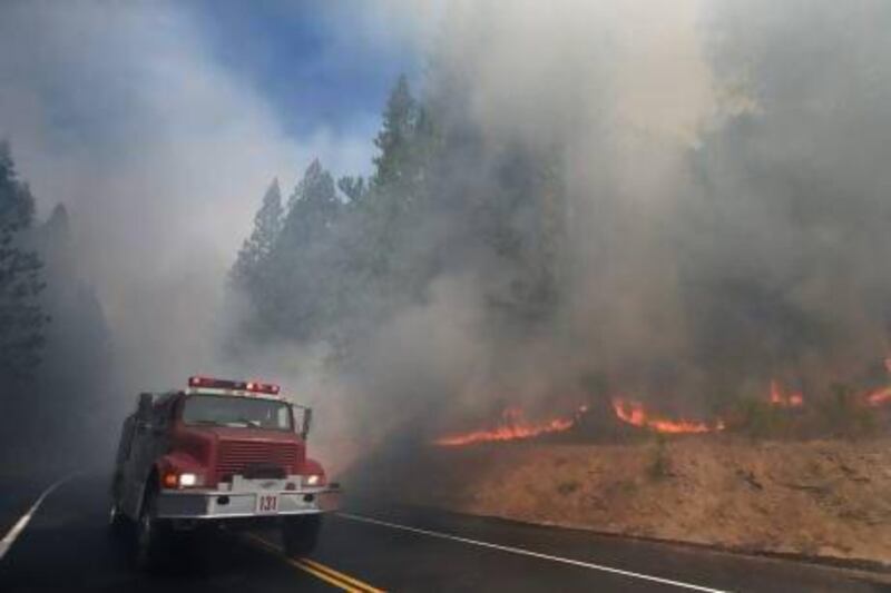A fire truck passes burning trees as firefighters continue to battle the Rim Fire near Yosemite National Park.