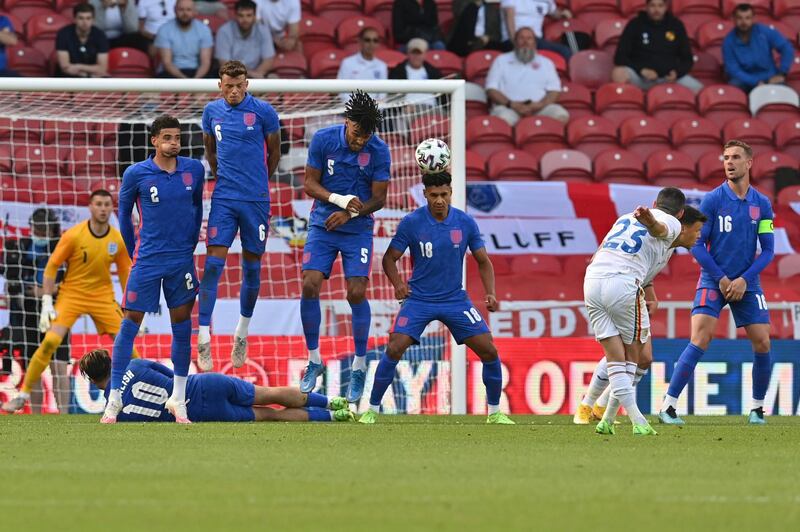 England's Tyrone Mings deflects a free kick taken by Romania's Nicolae Stanciu. AP