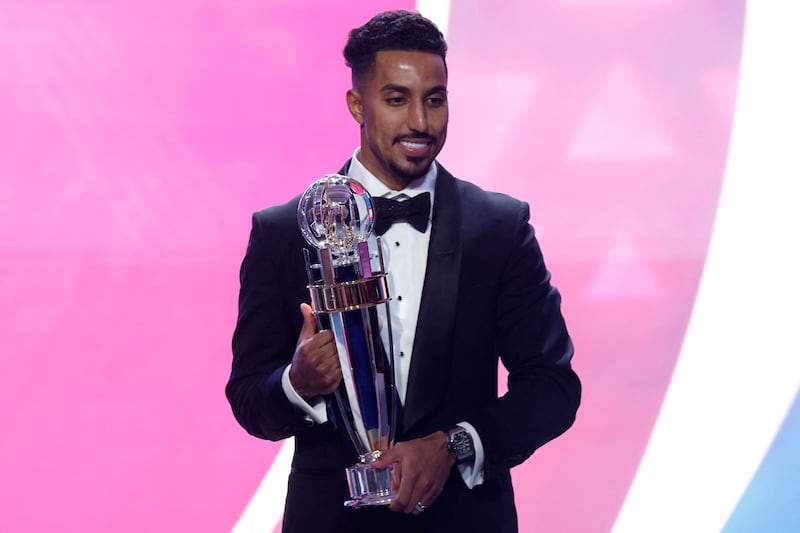 Saudi Arabia's forward Salem al-Dawsari poses for a picture with the AFC Player of the Year award during the AFC Annual Awards Doha 2022 on October 31, 2023.  (Photo by KARIM JAAFAR  /  AFP)