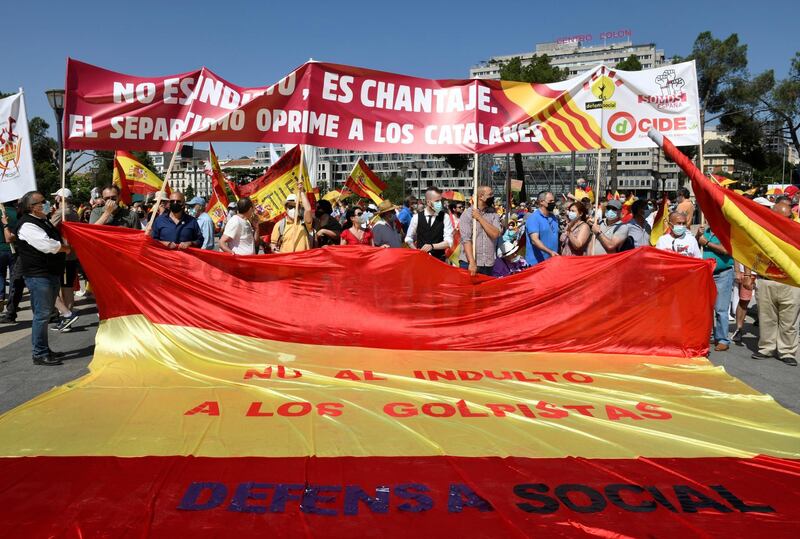 Several demonstrators hold a Spanish flag with the slogan  'No to Pardon for Participants in the Coup. Social Defense' written across it. EPA