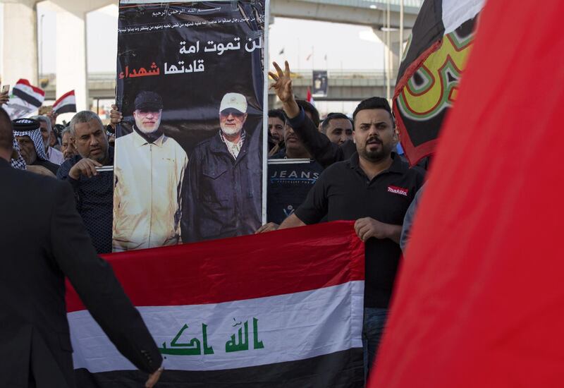 Iraqis carry a poster depicting Qassem Suleimani (right) and Abu Mahdi Al Muhandis as they march in a symbolic funeral procession in the southern city of Basra.  AFP