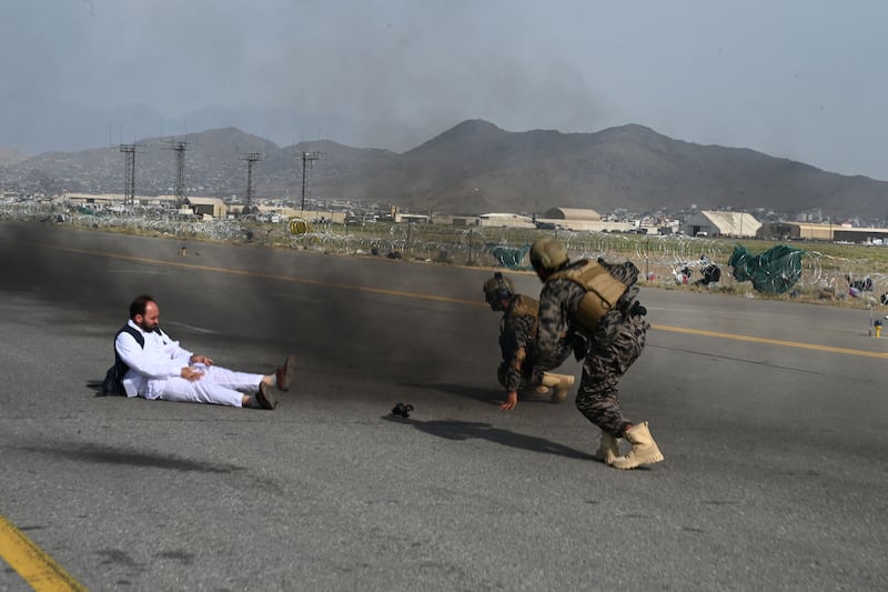 Taliban special force fighters and a journalist get up after they fell down from a vehicle at the airport in Kabul. AFP