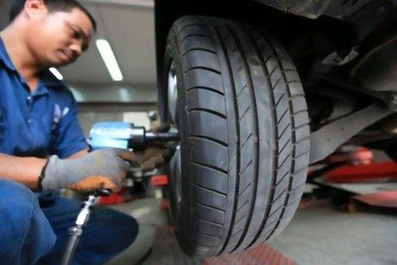 A worker at a tyre shop replacing new tyres in Abu Dhabi. Drivers are at a higher risk in summer when heat expands the air inside the tyres.