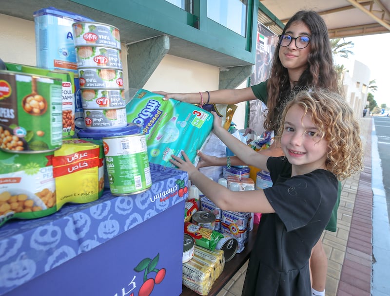 Eighth-year pupil Masa Oklah, and Aspen Murray, who is in the third year, during the aid collection drive for Gaza at the American Community School of Abu Dhabi. Victor Besa / The National
