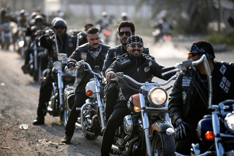 Members of Iraq's biker crew Bond Brothers MC take a break during a ride in the streets of the capital Baghdad on December 16, 2022.  (Photo by AHMAD AL-RUBAYE  /  AFP)