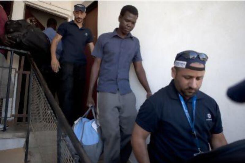 A Sudanese migrant is taken from his apartment to a detention camp before his expulsion by the Israeli immigration officers in Eilat last year. Menahem Kahana / AFP