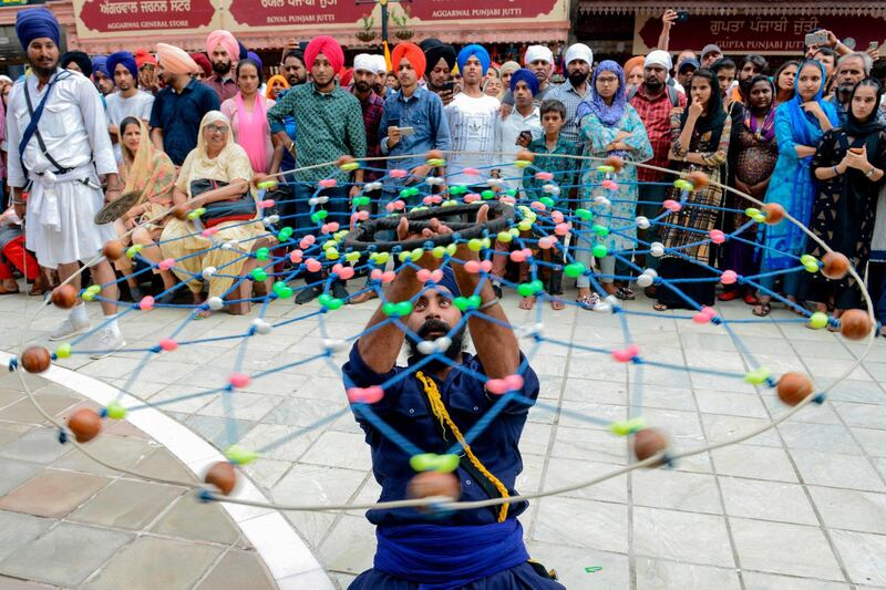 A Sikh devotee demonstrates his 'Gatka' traditional martial art skills during the 'Nagar Kirtan' procession to mark the 550th birth anniversary of Guru Nanak Dev, the founder of Sikhism, at the Golden Temple in Amritsar.  AFP