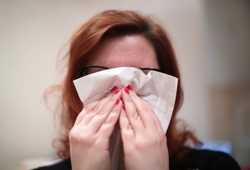 A woman blowing her nose with a tissue. Issue date: Wednesday March 23, 2022. PA