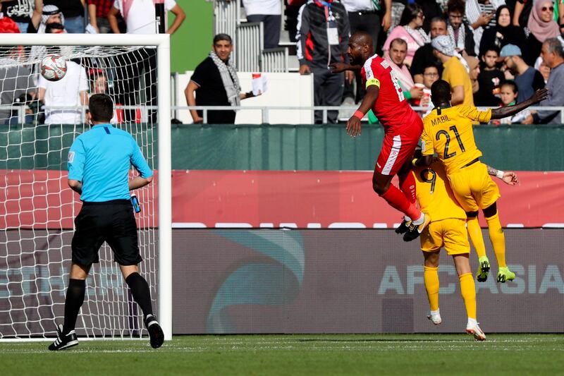 Palestine's Abdellatif Bahdari, left, fights for the ball with Australia's Awer Mabil. AFP