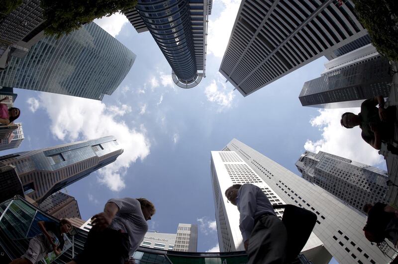 FILE PHOTO: People walk past office buildings at the central business district in Singapore in this April 14, 2015 REUTERS/Edgar Su/File Photo
