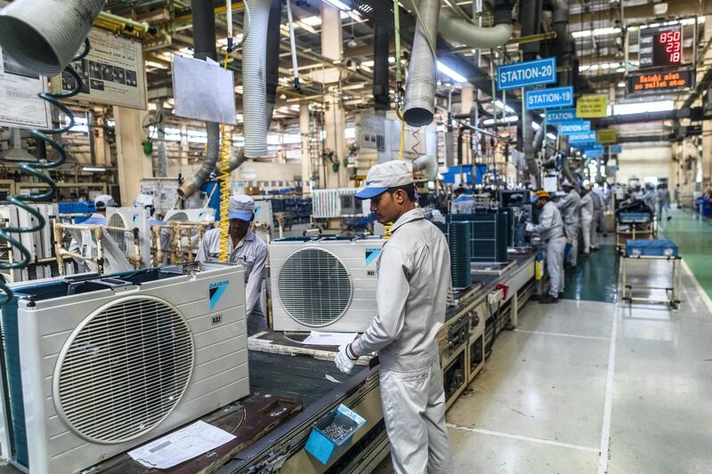 Employees work on the outdoor units of split system air conditioners on an assembly line at the Daikin Air Conditioning India Pvt. factory in the Rajasthan State Industrial Development and Investment Corporation's (RIICO) industrial complex in Neemrana, Rajasthan, India, on Friday, June 23, 2017. Japan’s foreign direct investment in India has risen since the global financial crisis, reaching nearly $3.5 billion in 2016. Photographer: Prashanth Vishwanathan/Bloomberg