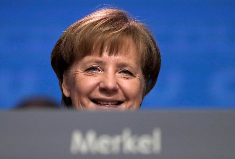 FILE - In this Feb. 26, 2018 file photo German Chancellor and party chairwoman Angela Merkel smiles at the party convention of the Christian Democratic Union CDU in Berlin. The members of the Social Democratic party voted for a coalition agreement with Merkel's party paving the way for Merkel's fourth term as German Chancellor.  (AP Photo/Markus Schreiber, file)