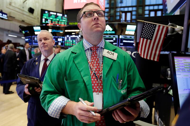 FILE - This Wednesday, Oct. 18, 2017, photo shows trader Ryan Falvey, who works on the floor of the New York Stock Exchange. What if the stock market plunged 20 percent tomorrow? The question may seem absurd when the market is in the midst of one of its calmest runs in history and at record highs. But it's what investors had to deal with 30 years ago, when "Black Monday" blasted stocks on Oct. 19, 1987. (AP Photo/Richard Drew, File)