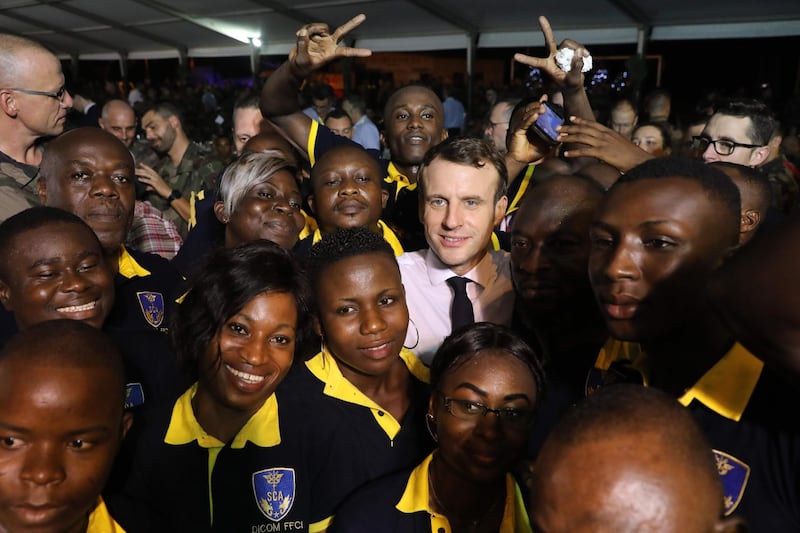 French President Emmanuel Macron poses with French soldiers and civilians during a Christmas dinner with French troops at the Port-Bouet military camp near Abidjan during his three day visit to West Africa.  AFP